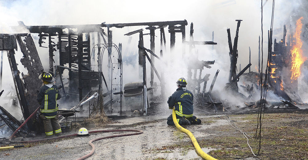 Spot News - 3rd place   - Leetonia firefighters Jordan Rhoads and Dan Joy, along with firefighters from Columbiana, work at bringing a fatal fire under control at Ray McFarland's Spruce Street home in Leetonia.  (Patricia Schaeffer / The (Lisbon) Morning Journal)